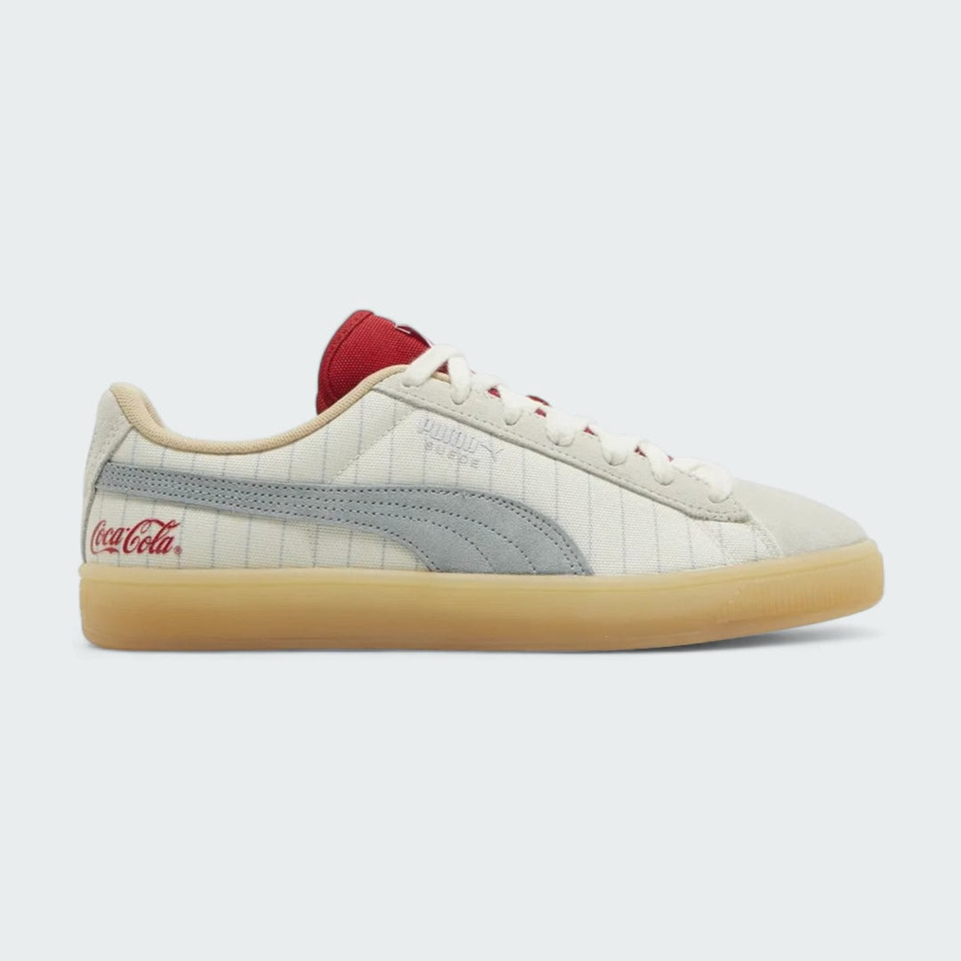Puma Suede x Coca-Cola Unisex trainers in white suede with a red Formstrip, side profile showing the classic silhouette and a Coca-Cola branded heel tab.