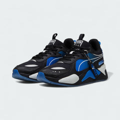 Angled view of two Puma RS-X x PlayStation Unisex trainers in black, side by side, showcasing their chunky silhouette and multi-colored gaming accents.