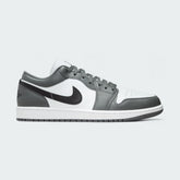 Air Jordan 1 Low Men's trainers in white, black, and grey, side profile showing leather upper, low-top design, and black Nike Swoosh.
