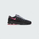 Nike Air Max Invigor Children's trainers in black with racer pink and cool grey accents, side profile showing mesh upper, prominent visible Max Air unit in the heel, and sleek silhouette.