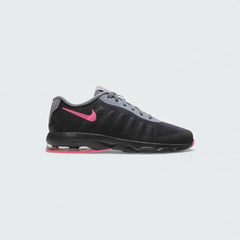 Nike Air Max Invigor Children's trainers in black with racer pink and cool grey accents, side profile showing mesh upper, prominent visible Max Air unit in the heel, and sleek silhouette.