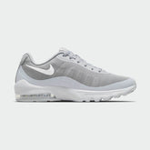 Nike Air Max Invigor Men's trainers in wolf grey with white accents, side profile showing mesh upper, prominent visible Max Air unit in the heel, and sleek silhouette.