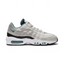 Nike Air Max 95 Essential Men's running shoes in beige with turquoise and black accents, side profile showing visible Max Air units in the heel and forefoot, and a layered upper.