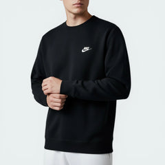 Person wearing a black Nike sweatshirt on a light gray background