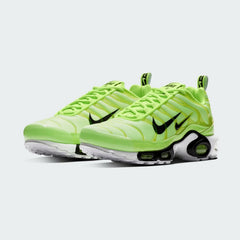 Angled view of two Nike Air Max Plus Men's "Lime Blast" trainers, side by side, emphasizing the vibrant colour scheme and Tuned Air technology.
