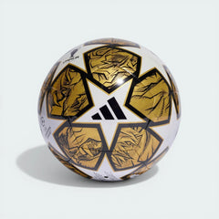 Side profile of the White and Gold UCL Club ball, highlighting the metallic star panels and black lion-inspired graphics.