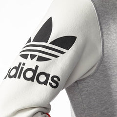 Close-up zoom on the Adidas Crew Basketball Sweatshirt in grey, showing the soft fleece fabric texture and any embroidered or printed Adidas branding detail.