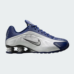 Nike Shox R4 women's trainers in blue void, side profile showing the four visible Shox cushioning columns in the heel and a sleek upper with a Nike Swoosh.
