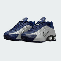 Angled view of two Nike Shox R4 women's trainers in blue void, side by side, showcasing their bold, tech-inspired design.