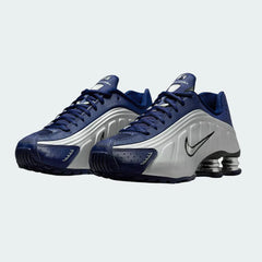 Angled view of two Nike Shox R4 women's trainers in blue void, side by side, showcasing their bold, tech-inspired design.