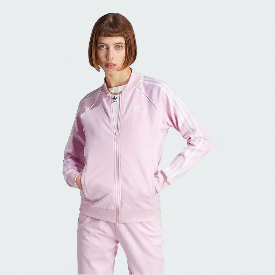 Adidas Adicolor Classics Superstar Track Jacket in orchid fusion pink, front view showing full zip, stand-up collar, white 3-Stripes on sleeves, and embroidered Trefoil logo.
