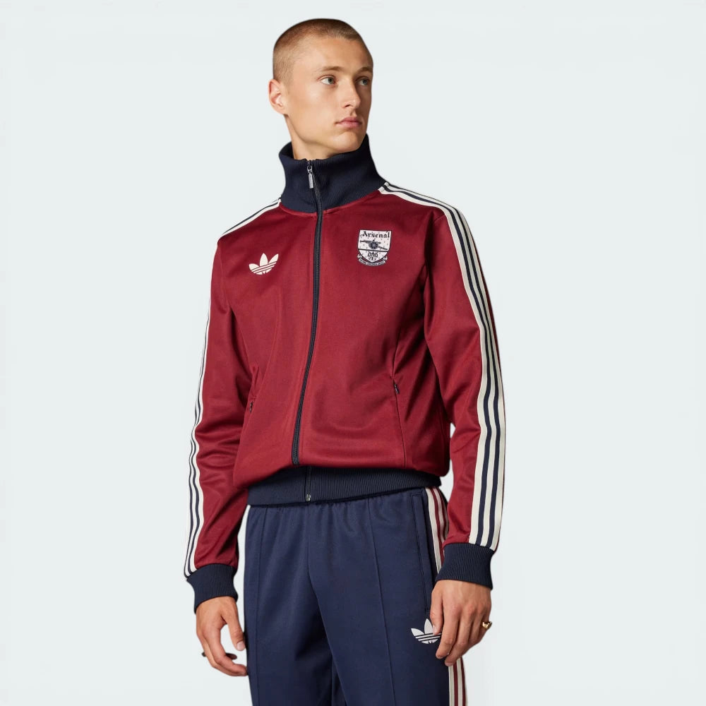 Side profile of the Noble Maroon Arsenal track top, highlighting the slim sleeve construction and the classic white 3-Stripes running down the arm.