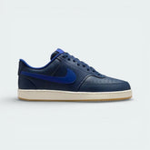 Side profile of the Nike Court Vision Low in Midnight Navy, showing the tonal leather panels and the clean Deep Royal Blue Swoosh.