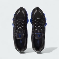 Top-down view of a pair of Nike Shox TL men's sneakers in black and silver, highlighting their structured silhouette and lace-up closure.