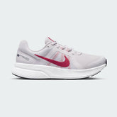 Nike Run Swift 2 Women's running shoes in pink with white accents, side profile showing breathable mesh upper, foam midsole, and Nike Swoosh.