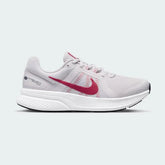 Nike Run Swift 2 Women's running shoes in pink with white accents, side profile showing breathable mesh upper, foam midsole, and Nike Swoosh.