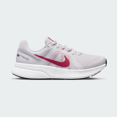 Nike Run Swift 2 Women's running shoes in pink with white accents, side profile showing breathable mesh upper, foam midsole, and Nike Swoosh.