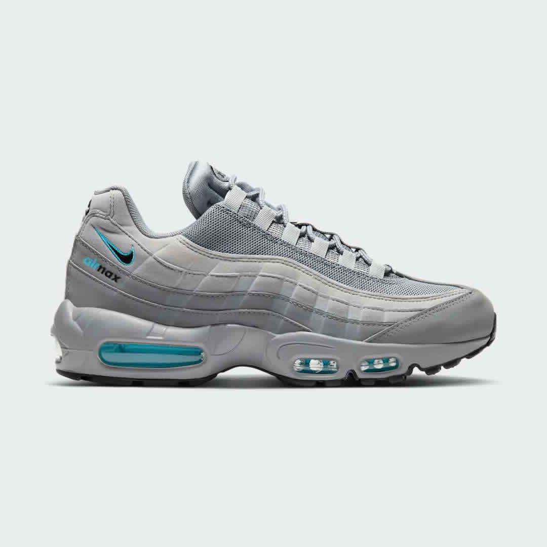 Nike Air Max 95 Men's running shoes in shades of grey with blue and black accents, side profile showing visible Max Air units in the heel and forefoot, and a layered upper.