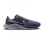 Highlights the high-velocity sweep of the Wolf Grey Nike Swoosh, showing the crisp, dual-tone texture of the Thunder Blue mesh upper resting above the textured black React foam midsole wall.
