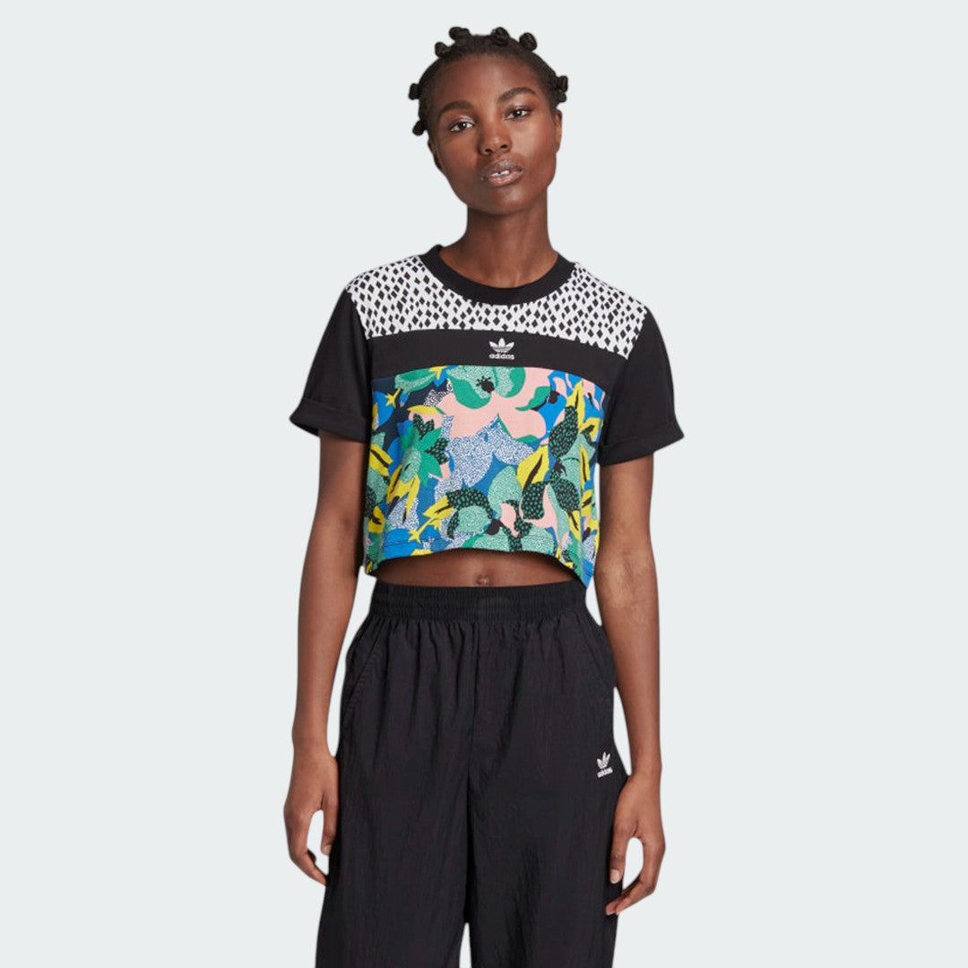 Woman wearing the Adidas x Her Studio London Cropped Tee with a multicolour floral print, demonstrating its stylish fit and cropped length.