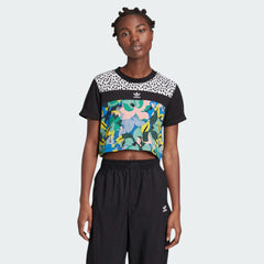 Woman wearing the Adidas x Her Studio London Cropped Tee with a multicolour floral print, demonstrating its stylish fit and cropped length.