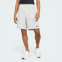 Side profile of the Dark Grey Heather Nike fitness shorts, showing the relaxed fit and the subtle black embroidered Swoosh on the lower left leg.