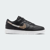 Nike Dunk Low SE Women's trainers in black leather with a white midsole, side profile showing classic silhouette, perforated toe box, and Nike Swoosh.