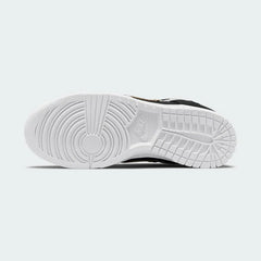 View of the outsole of the Nike Dunk Low SE Women's black leather trainers, showing the durable rubber sole with pivot circles for traction.