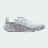 Nike Quest 5 Women's running shoe in white with metallic silver accents, side profile showing breathable mesh upper, foam cushioning, and Nike Swoosh.