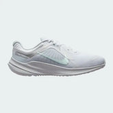 Nike Quest 5 Women's running shoe in white with metallic silver accents, side profile showing breathable mesh upper, foam cushioning, and Nike Swoosh.