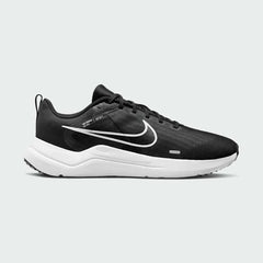 Nike Downshifter 12 Men's training shoes in black with a white midsole, side profile showing mesh upper, foam cushioning, and Nike Swoosh.