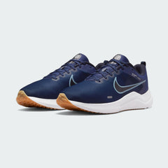 Angled view of two Nike Downshifter 12 Men's navy blue and white training shoes, side by side, showcasing their versatile design and cushioned profile.