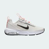 Nike Air Max Intrlk Lite Juniors' running trainers in summit white and black, side profile showing visible Max Air unit and layered mesh upper.
