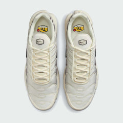 Top-down view of a pair of Nike Air Max Plus TN Men's trainers in beige, highlighting their iconic silhouette and lace-up closure.