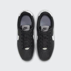 Top-down view of a pair of Nike Cortez Juniors' trainers in black, highlighting their sleek profile and lace-up closure.