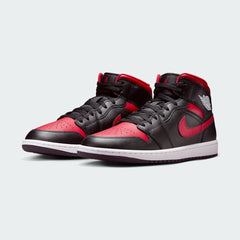Angled view of two Air Jordan 1 Mid Men's black, red, and white trainers, side by side, showcasing their iconic design and bold color blocking.