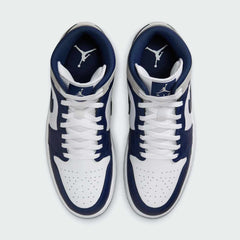 Top-down view of a pair of Air Jordan 1 Mid Men's trainers in white, blue, and black, highlighting their classic silhouette and lace-up closure.
