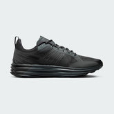 Nike Lunar Roam Men's trainers in dark smoke grey and black, side profile showing plush Lunar foam midsole and breathable textile upper.