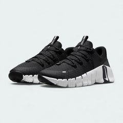 Angled view of two Nike Free Metcon 5 Men's black and white training shoes, side by side, showcasing their dynamic design and supportive structure.