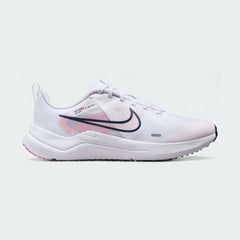 Nike Downshifter 12 Premium Women's training shoes in white with metallic gold accents, side profile showing mesh upper, foam cushioning, and Nike Swoosh.