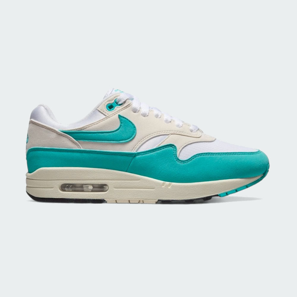 Nike Air Max 1 Women's trainers in white with a dusty cactus blue-green Swoosh, side profile showing visible Max Air unit in the heel and a layered mesh and synthetic leather upper.
