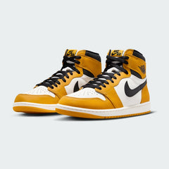 Angled view of two Air Jordan 1 Retro High OG Men's trainers in yellow, black, and sail, side by side, showcasing their iconic design and bold color blocking.