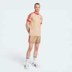 Angle view showing the front of the tee, emphasizing the premium embroidered Trefoil logo on the chest.