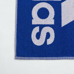 Detailed view of a corner of the Adidas Cotton Towel in royal blue, highlighting the stitched edges and the embroidered white Adidas logo.