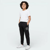 Child wearing a white t-shirt and black pants with text on a white background
