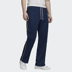 Adidas Recycled Track Pants Men's in dark blue, front view showing elastic waistband, drawcord, side pockets, and contrasting 3-Stripes down the legs.