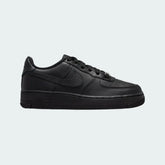 Nike Air Force 1 Juniors' trainers in black leather, side profile showing classic leather upper, perforated toe box, and Nike Swoosh.