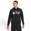 Studio front three-quarter view of a male model wearing the black Nike Swoosh Dri-FIT pullover hoodie, highlighting the distressed white arched "NIKE" chest graphic, matching black drawstrings, and the front kangaroo pocket.