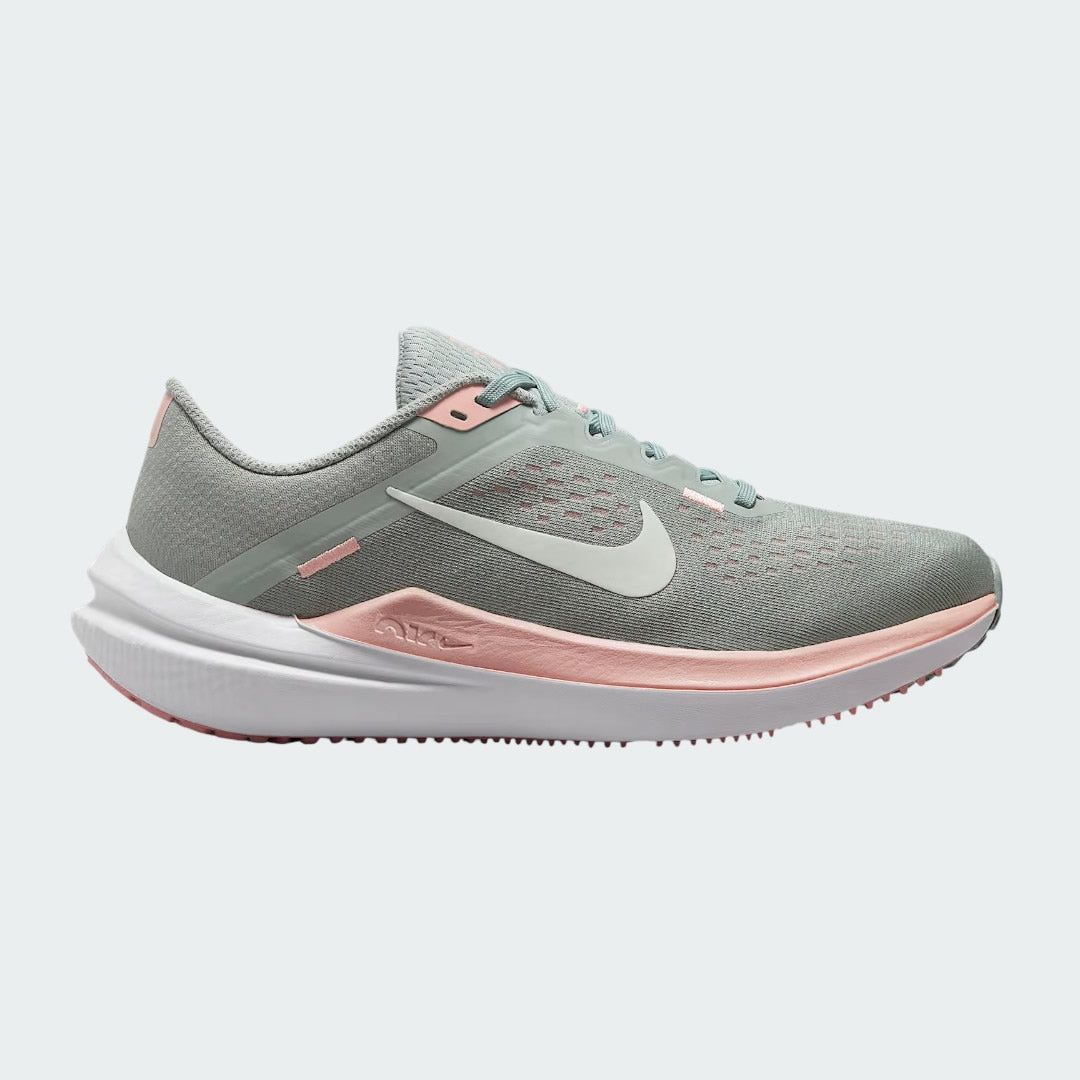 Nike Air Winflo 10 Women's running shoes in green with white accents, side profile showing engineered mesh upper, prominent Nike Swoosh, and cushioned Air midsole.