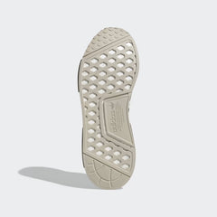 View of the outsole of the Adidas NMD_R1 women's shoes, showing the durable rubber tread pattern and visible Boost cushioning.